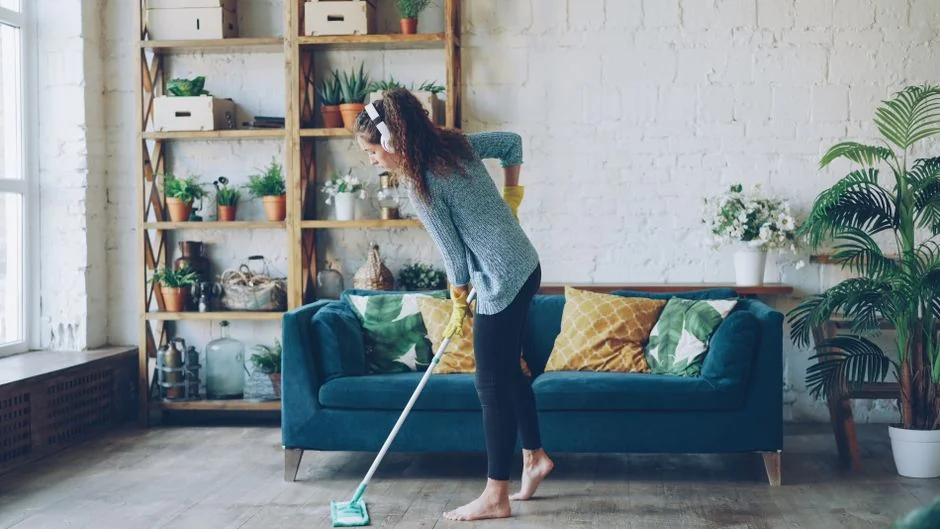 Cleaner using a vacuum in a stylish indoor setting, showcasing cleaning equipment and techniques.